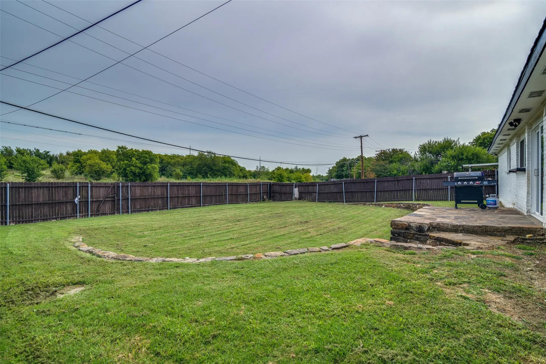 Fenced backyard featuring a patio