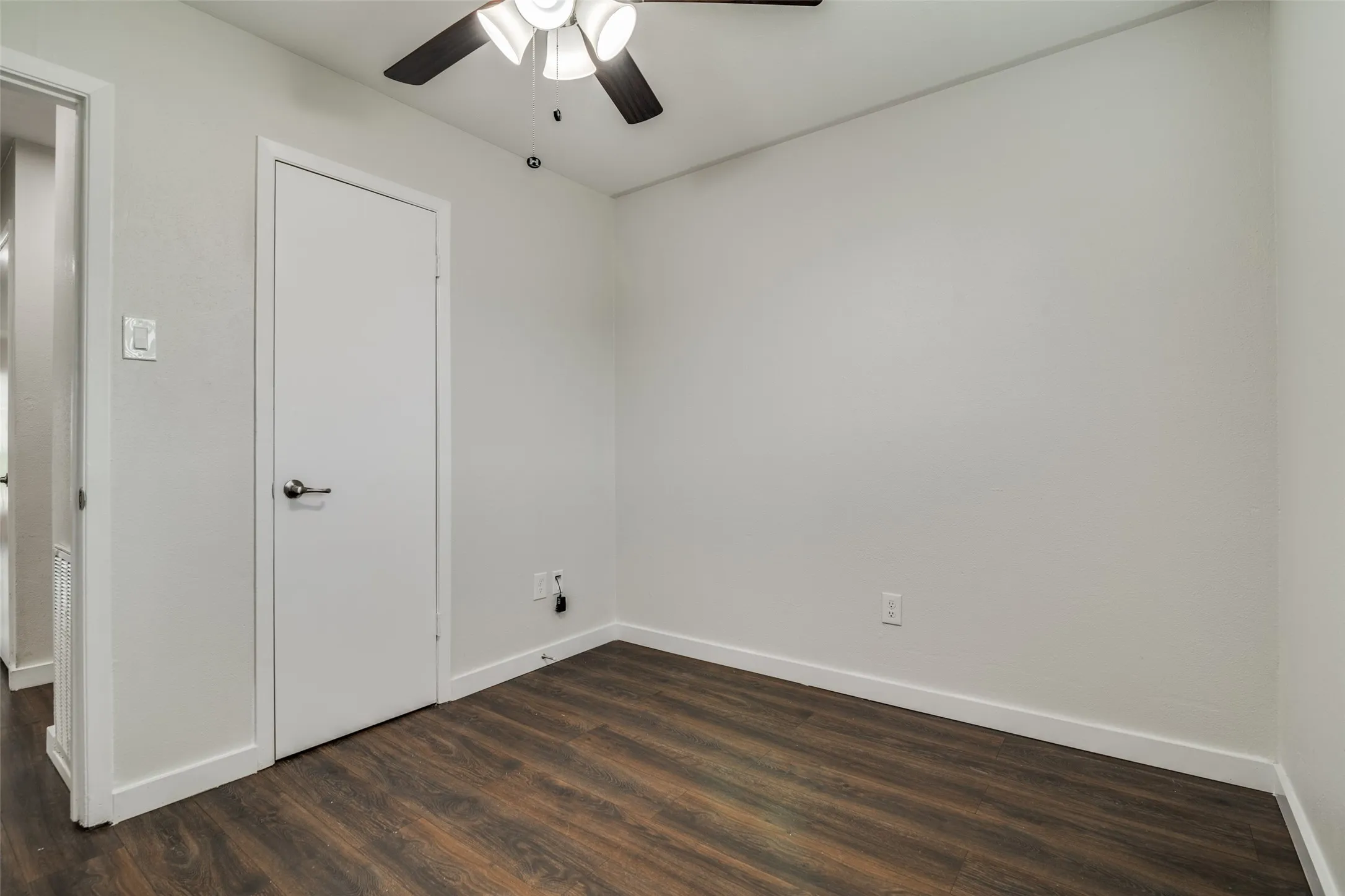 Unfurnished bedroom featuring dark wood finished floors and ceiling fan