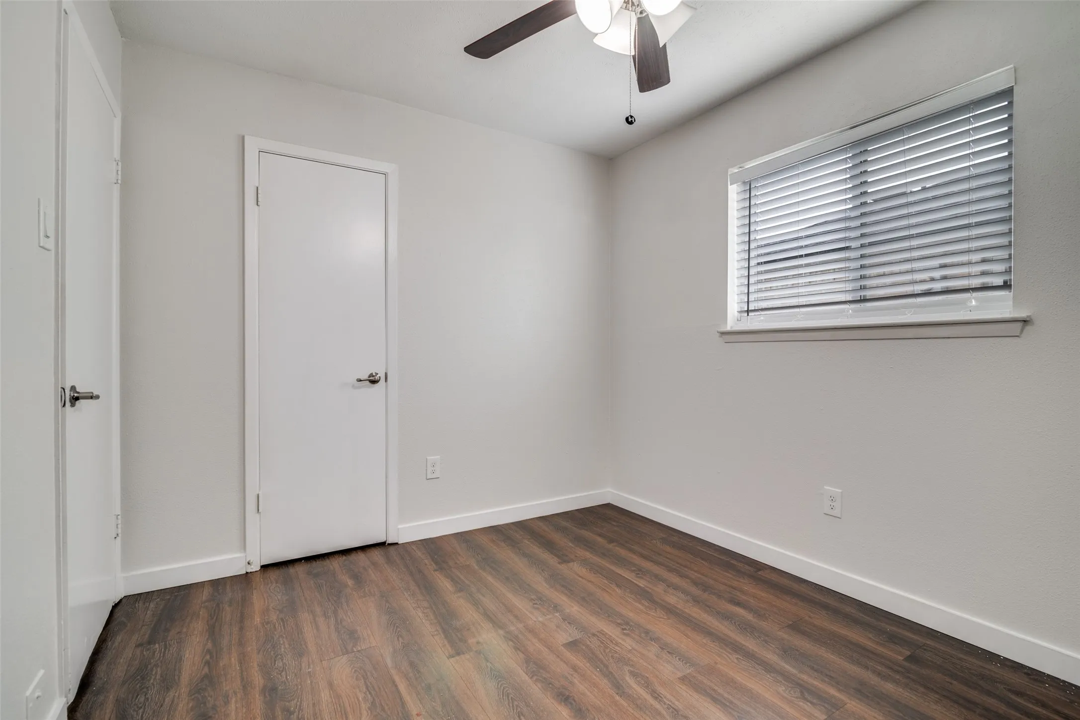 Unfurnished bedroom with dark wood-style flooring and ceiling fan