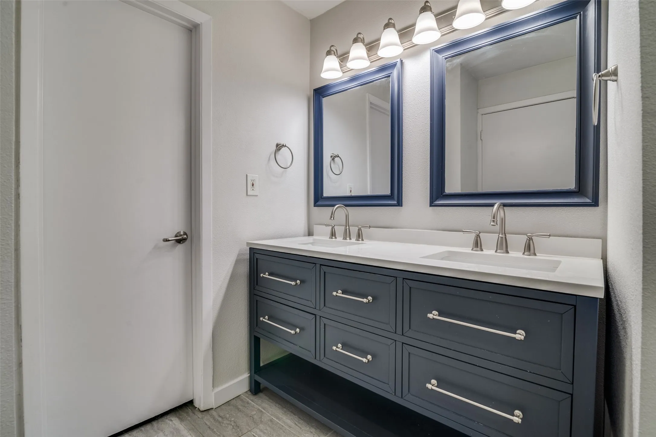Bathroom featuring double vanity and baseboards