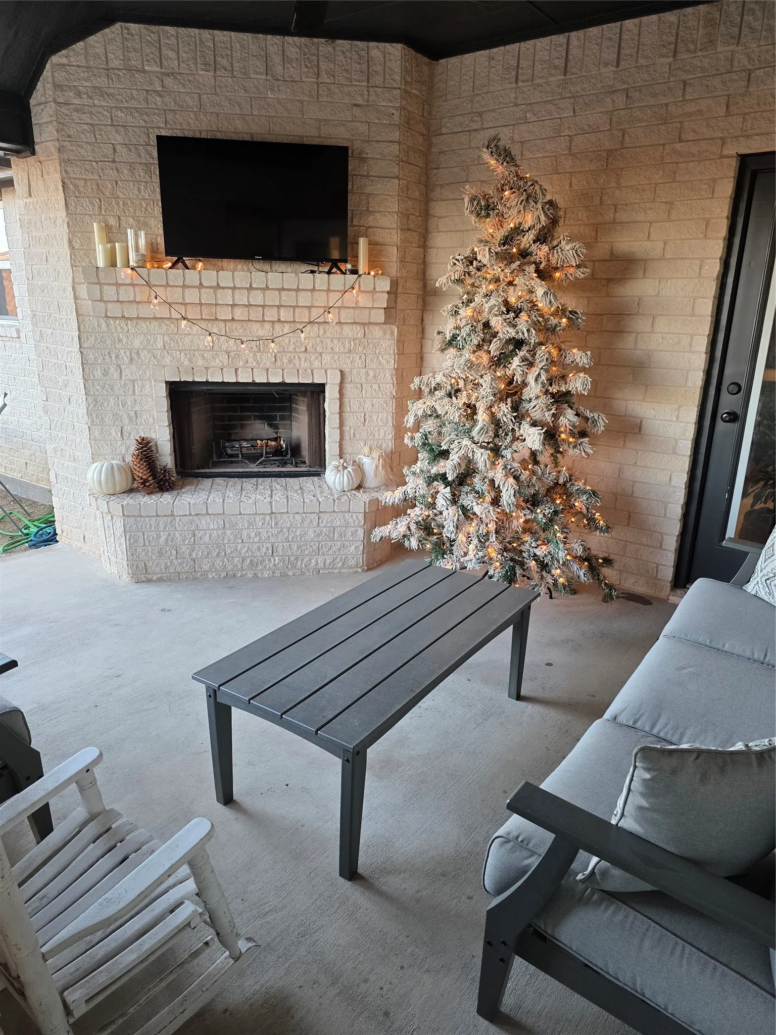 View of patio / terrace with an outdoor brick fireplace and outdoor plugs