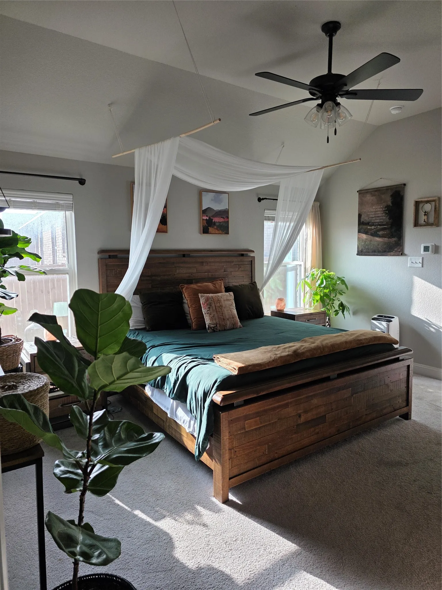 Bedroom featuring carpet, multiple windows, and a ceiling fan