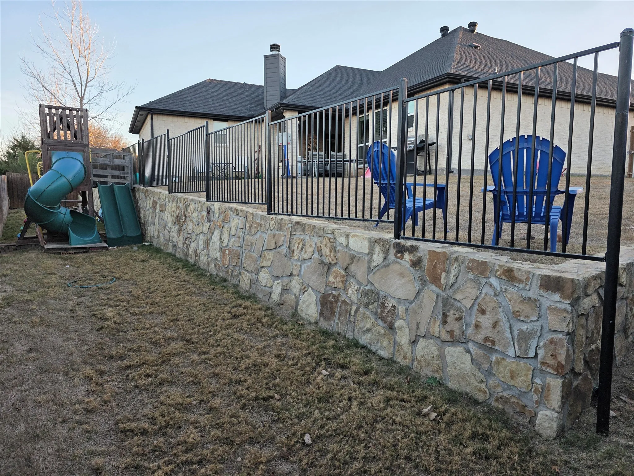 Rear view of property featuring a patio area, a playground, and a chimney
