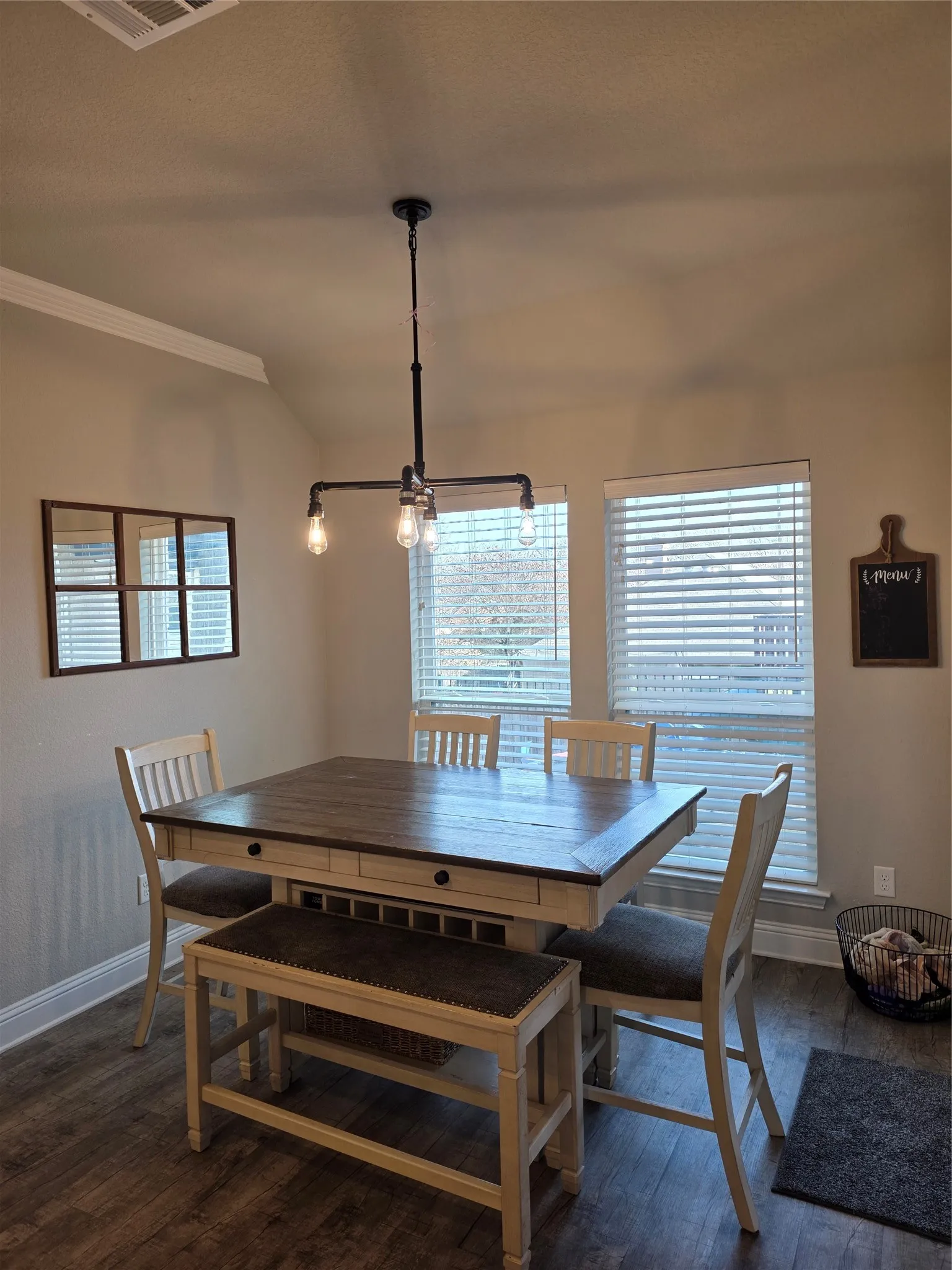 Dining space with dark wood finished floors and healthy amount of natural light