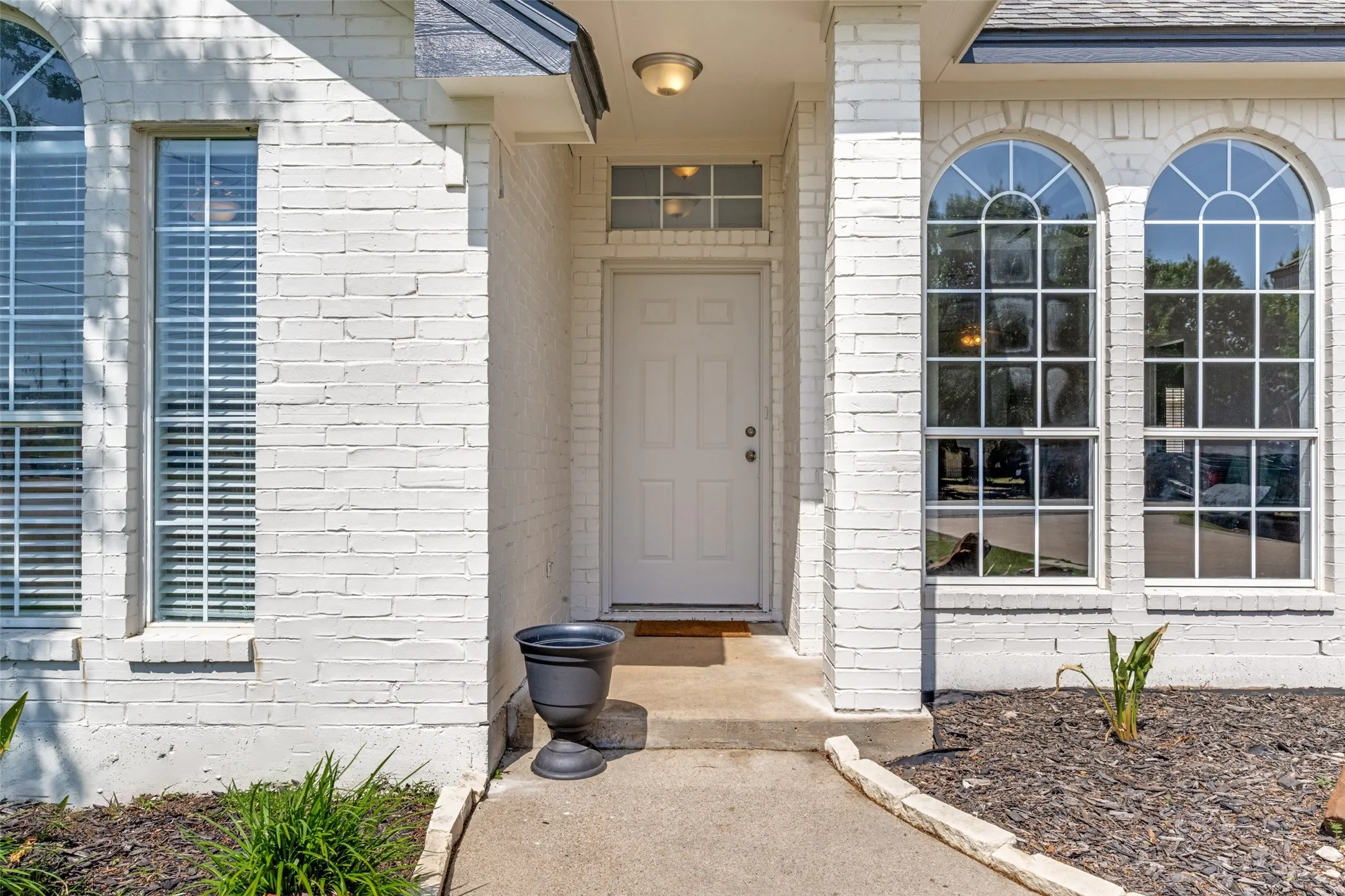 White brick exterior with a covered entry