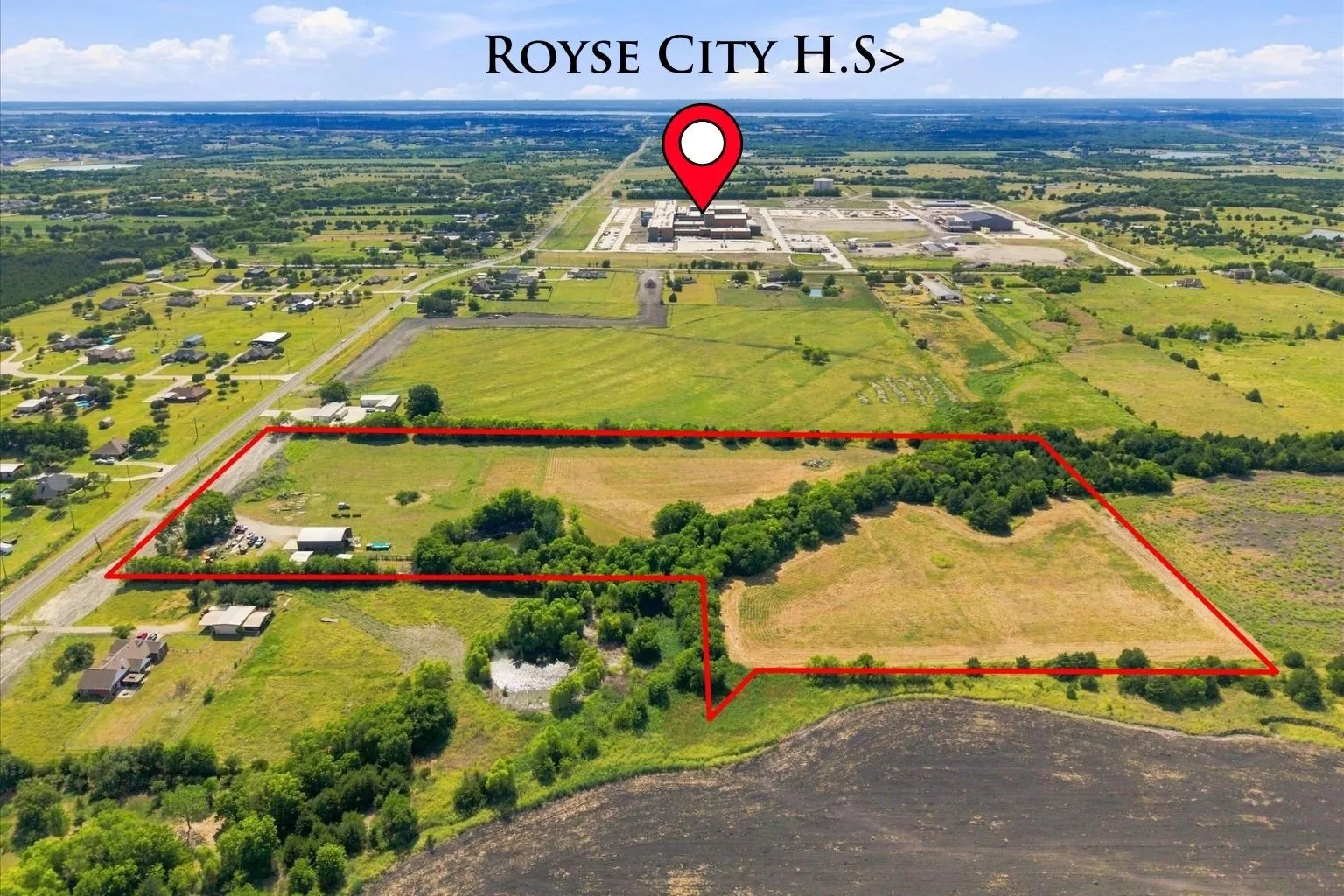 Expansive rural property featuring open fields and mature tree lines