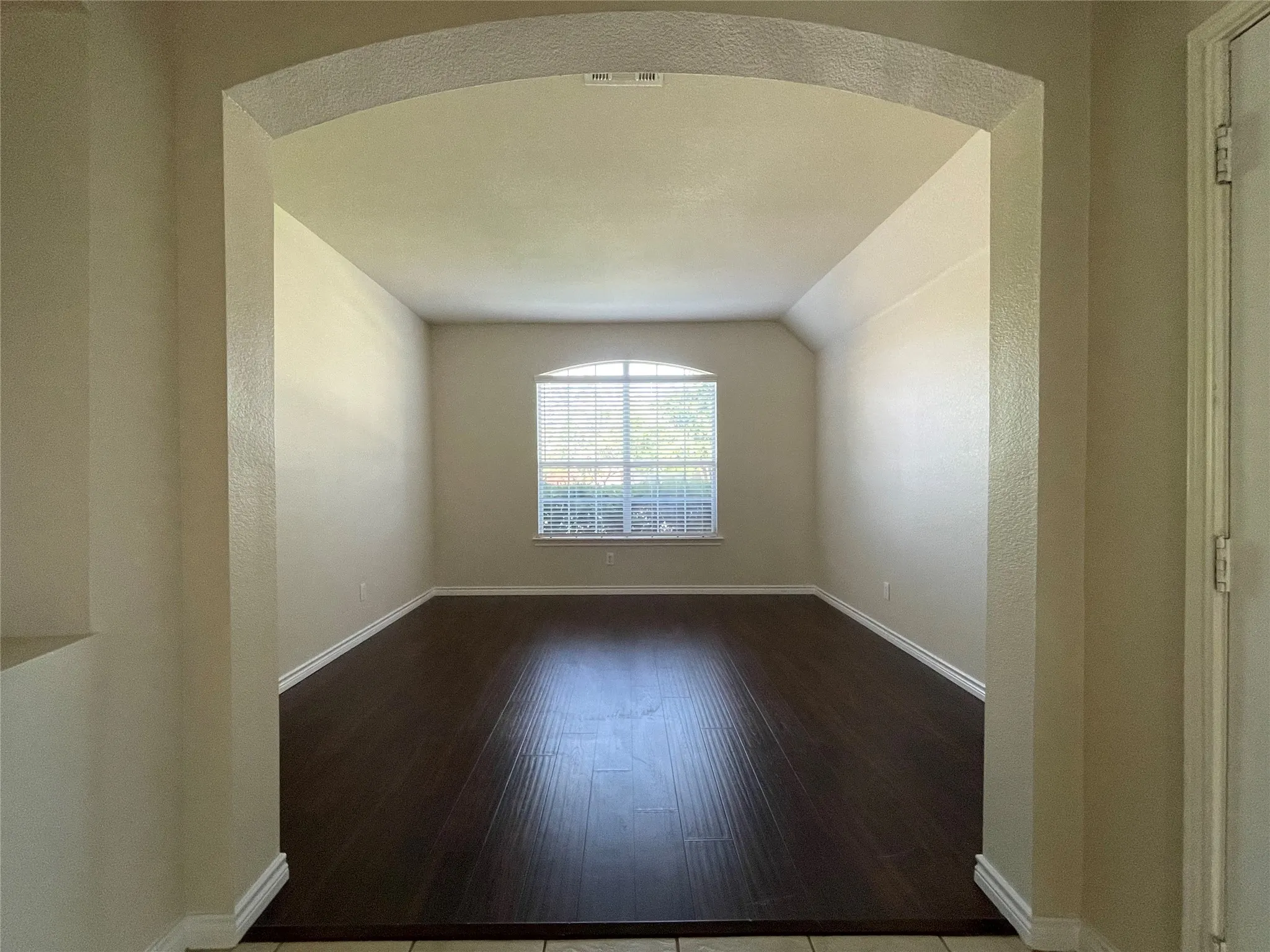 Unfurnished room with vaulted ceiling and hardwood / wood-style floors