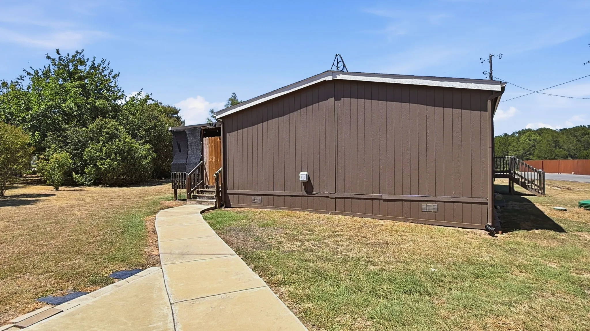 Side view of home with concrete sidewalk