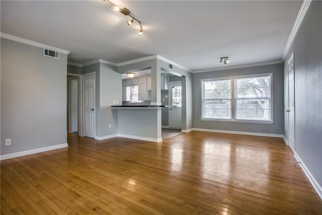 Hardwood flooring, crown molding, double windows, track lighting, and a pass-through bar