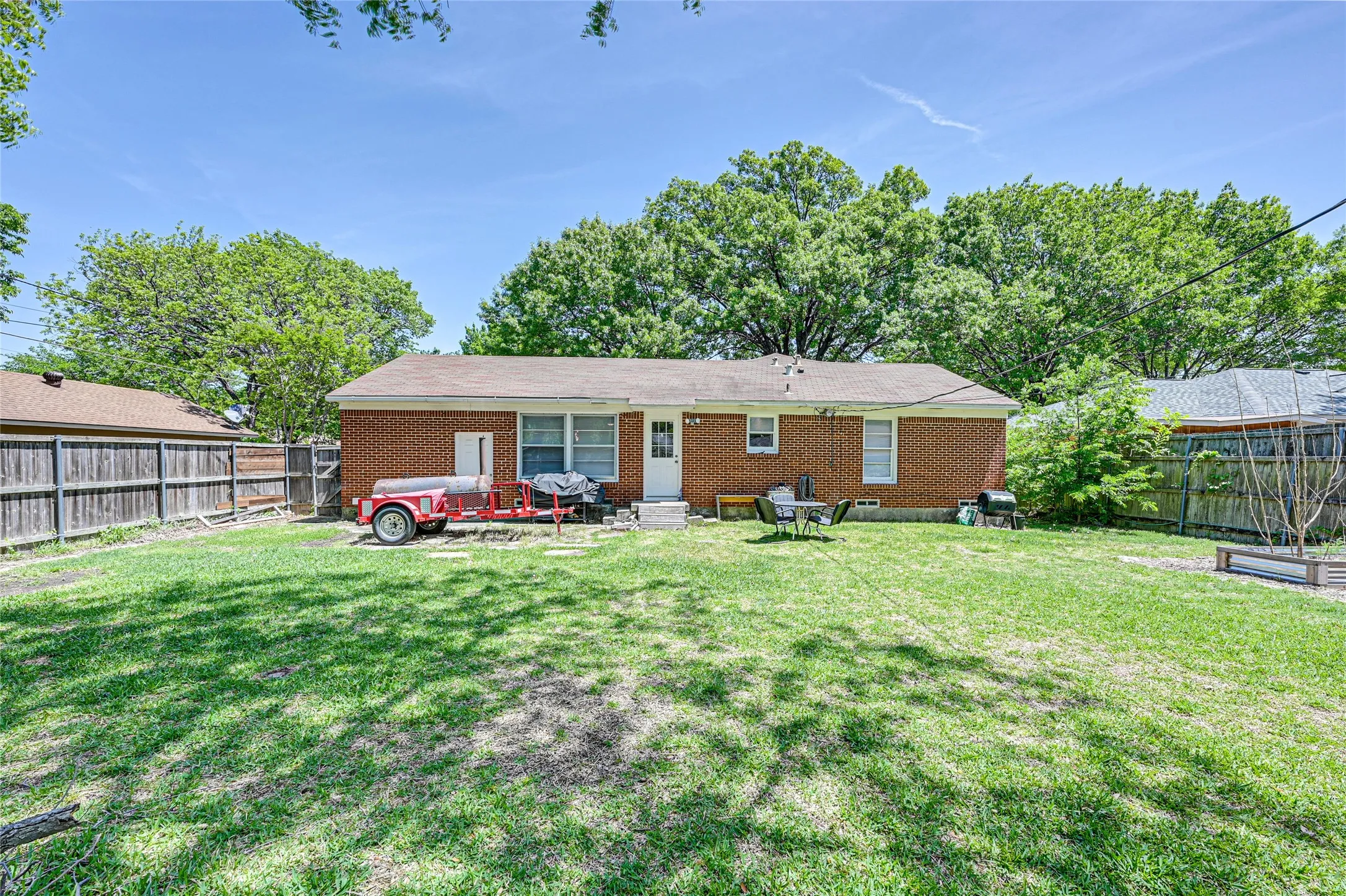 Expansive grassy yard featuring a brick exterior and wood fencing