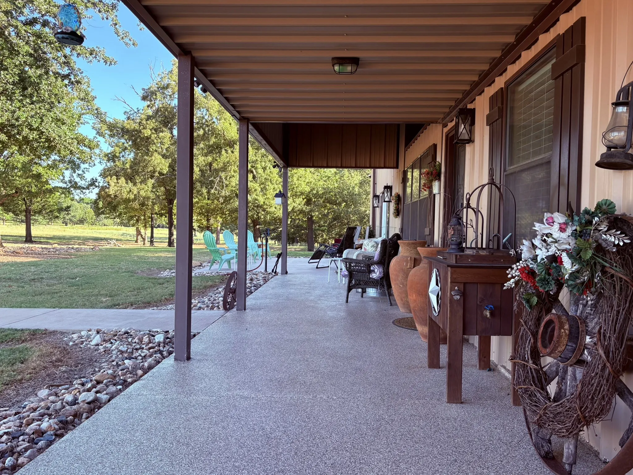 Expansive covered porch featuring a speckled concrete surface and robust support pillars