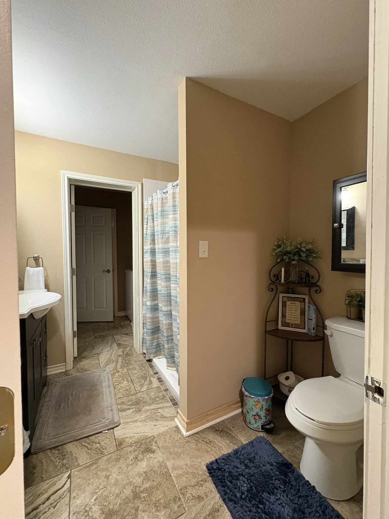 Recessed lighting, wood-finish vanity with integrated sink, tiled flooring, standing shower, and a commode
