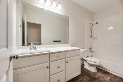 White vanity with integrated sink, chrome faucet, and white countertop