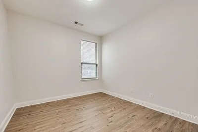 Recessed ceiling lighting, wood-finish flooring, single window with blinds, and light-toned walls