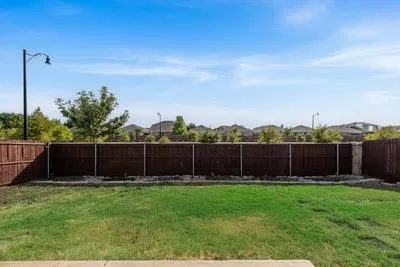 Expansive backyard featuring a manicured lawn and privacy fencing
