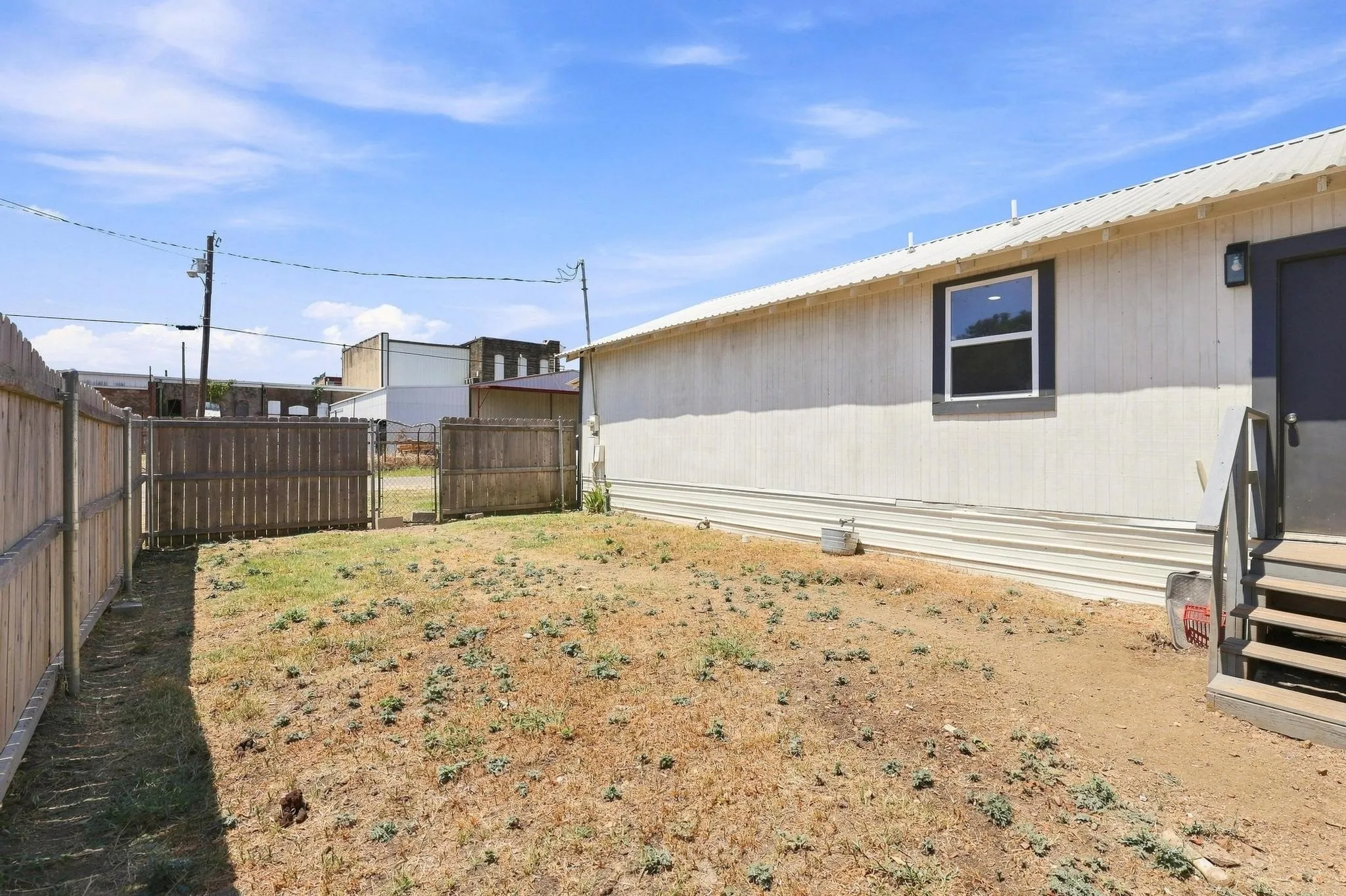 Fenced yard featuring wood picket fencing, exterior siding, and a window with dark trim