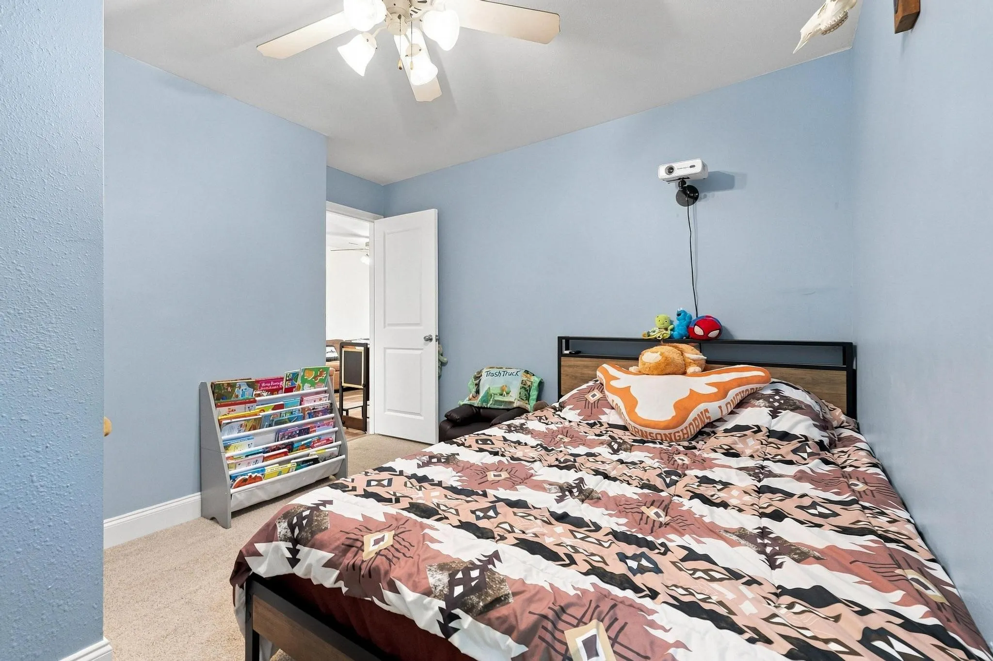 Carpeted flooring, ceiling fan with light fixture, and a white interior door