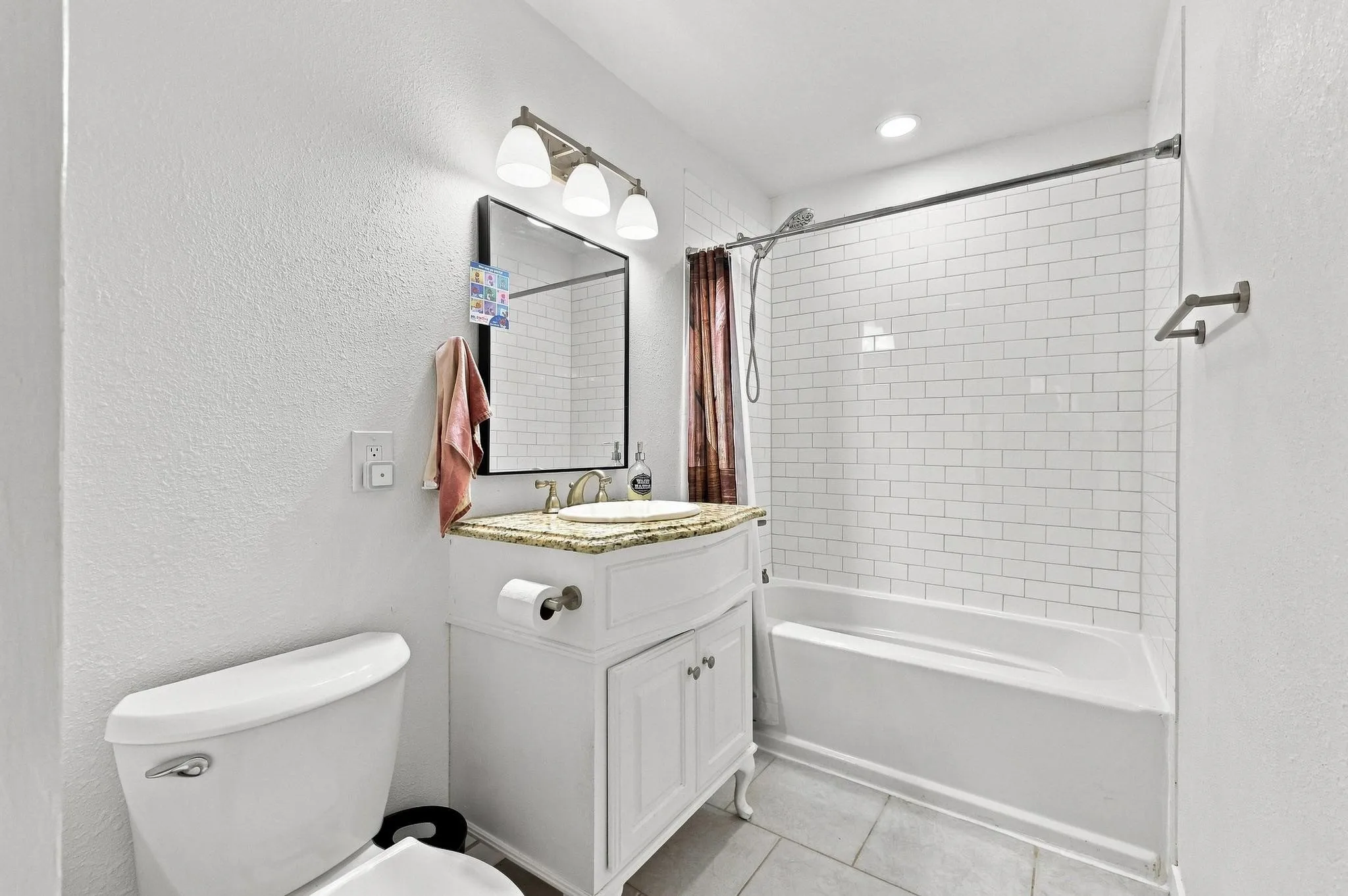 Vanity with a light-colored countertop, undermount sink, and polished brass fixtures