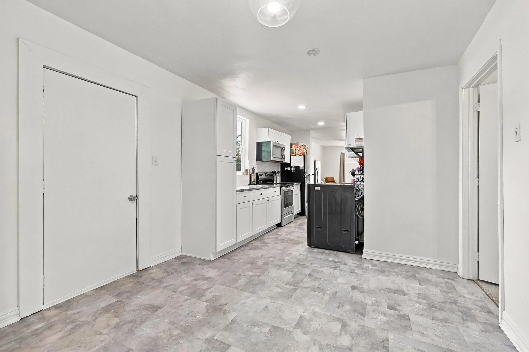 Spacious foyer with herringbone wood-finish flooring, recessed lighting throughout, and multiple white painted doors providing access to primary living spaces