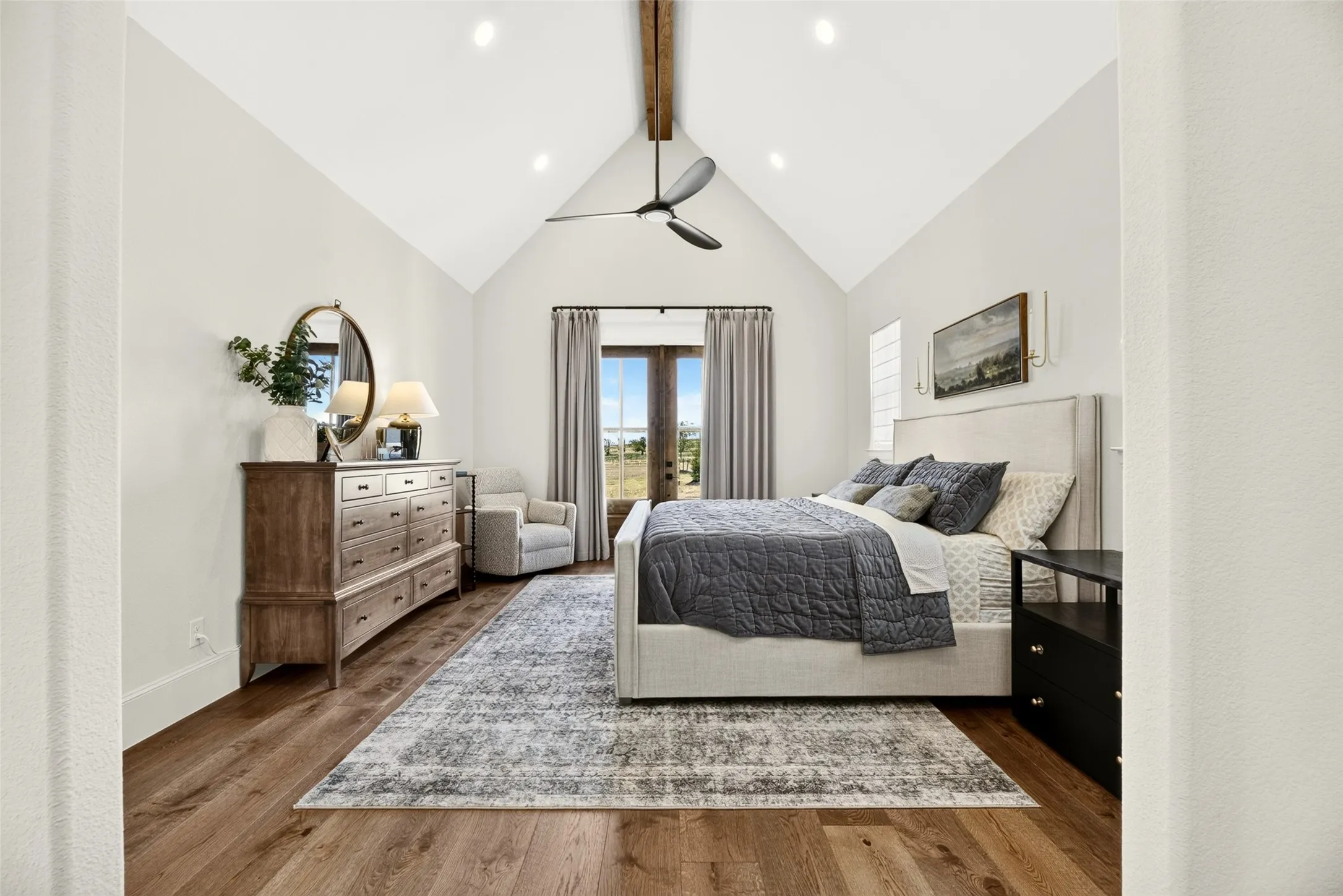 Vaulted ceiling with exposed wood beam, wood-finish flooring, recessed lighting, and double doors