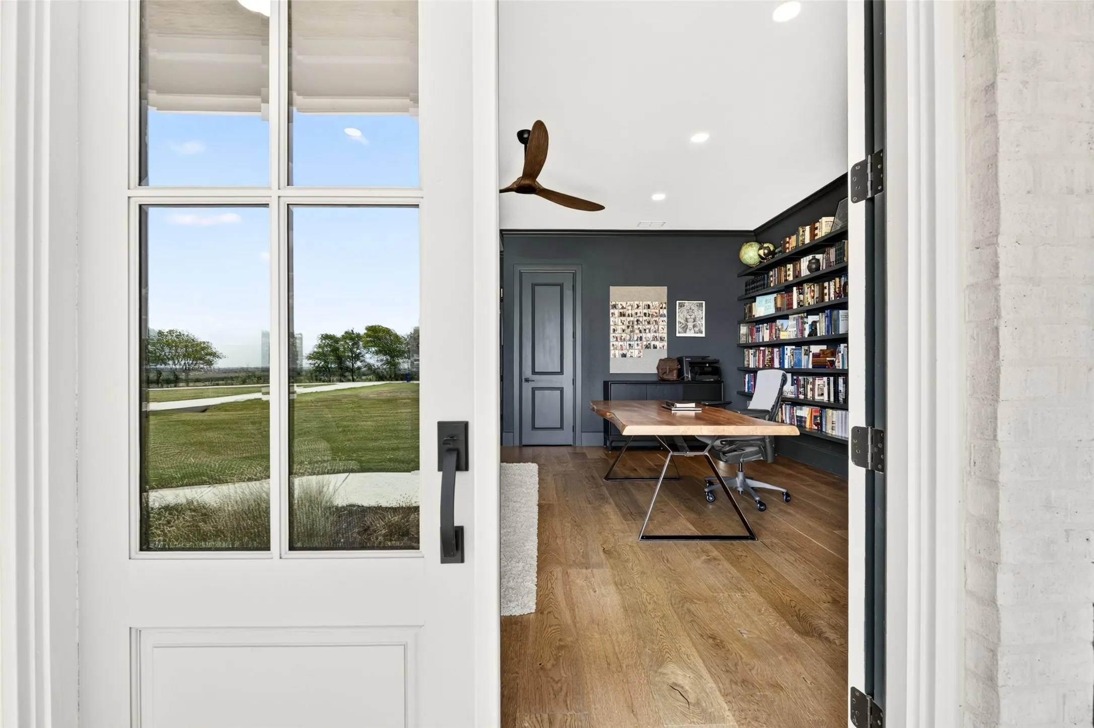 Interior space featuring wood-finish flooring, recessed lighting, and a built-in wall-mounted shelving unit