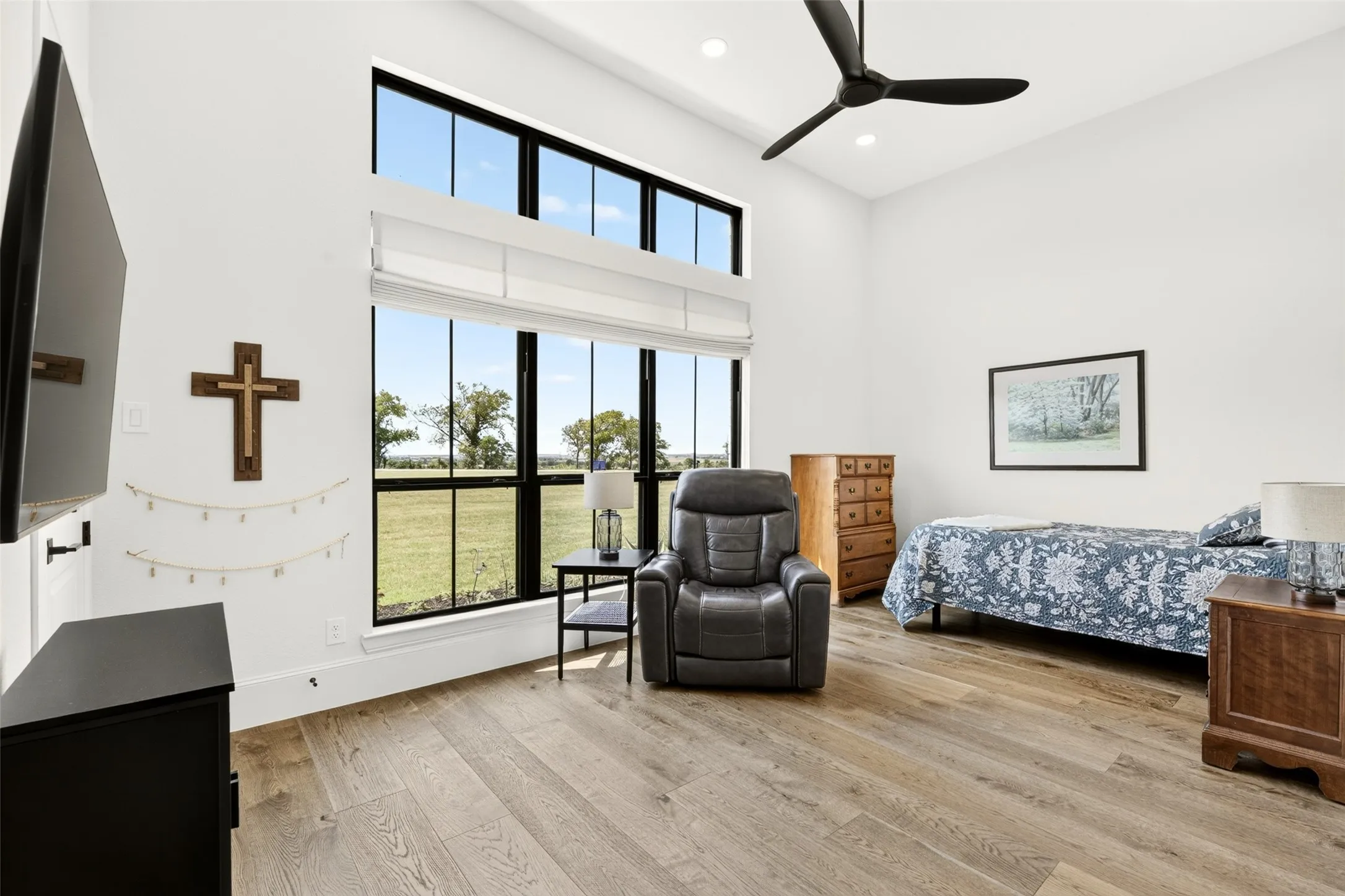 Vaulted ceiling with a ceiling fan, full-height windows, wood-finish flooring, and recessed lighting