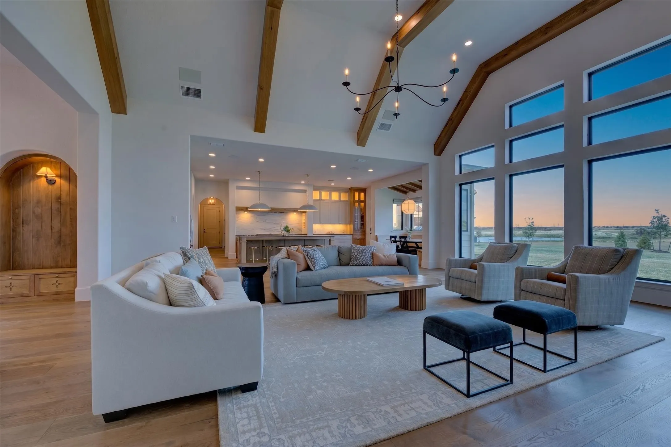 Vaulted ceilings with exposed wood beams, expansive windows, wood-finish flooring, built-in archway nook with sconce, and recessed lighting