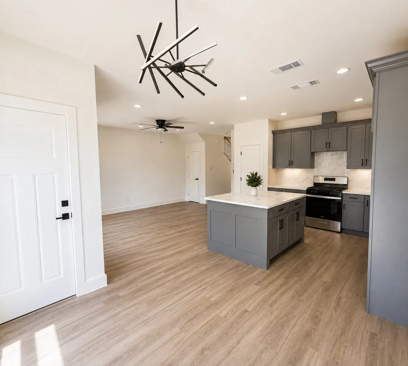 Open-concept living space with wood-finish flooring, a modern chandelier, and recessed lighting