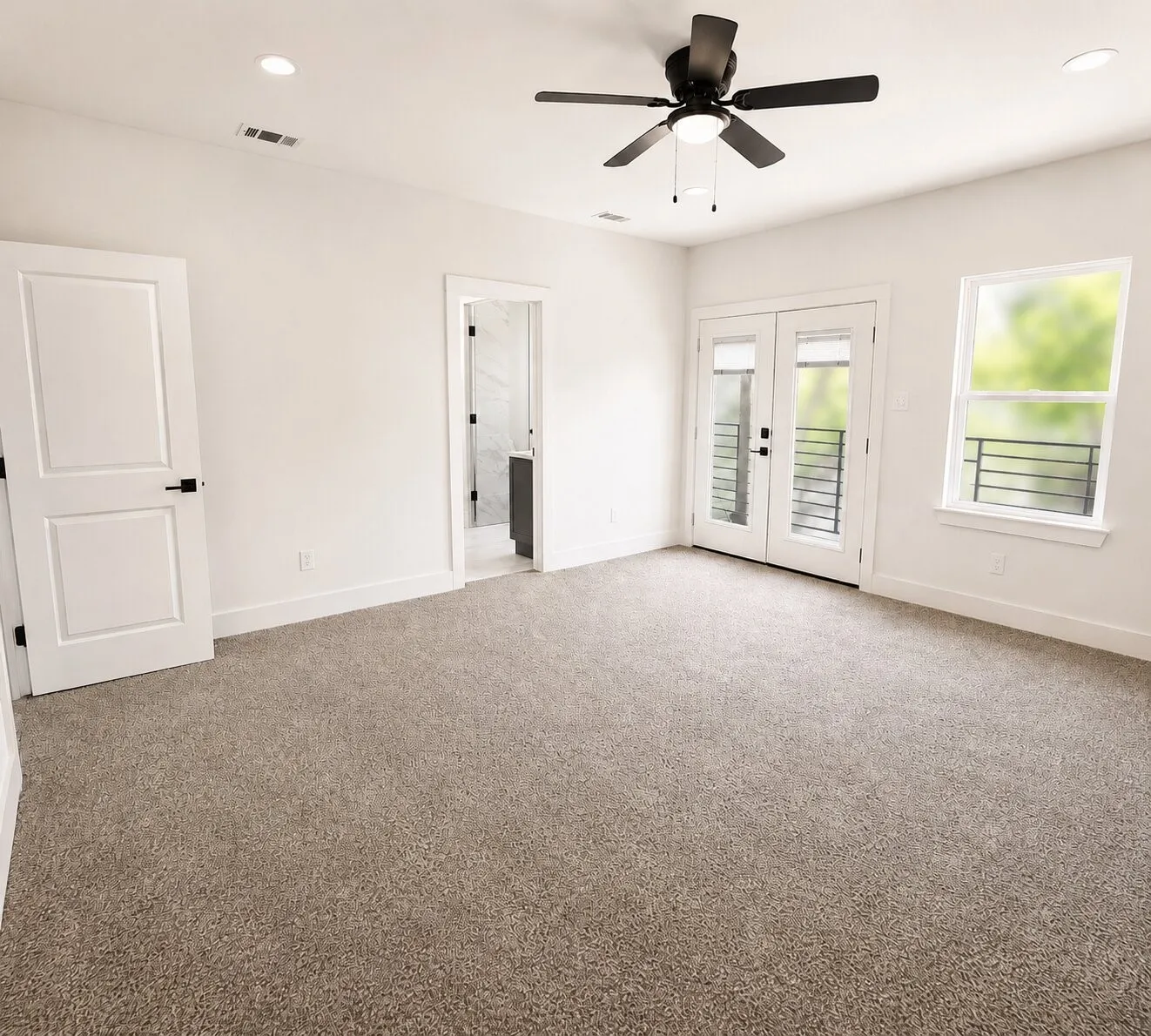 Plush carpeting, ceiling fan with integrated lighting, white double French doors, large window with iron railing, and recessed lighting