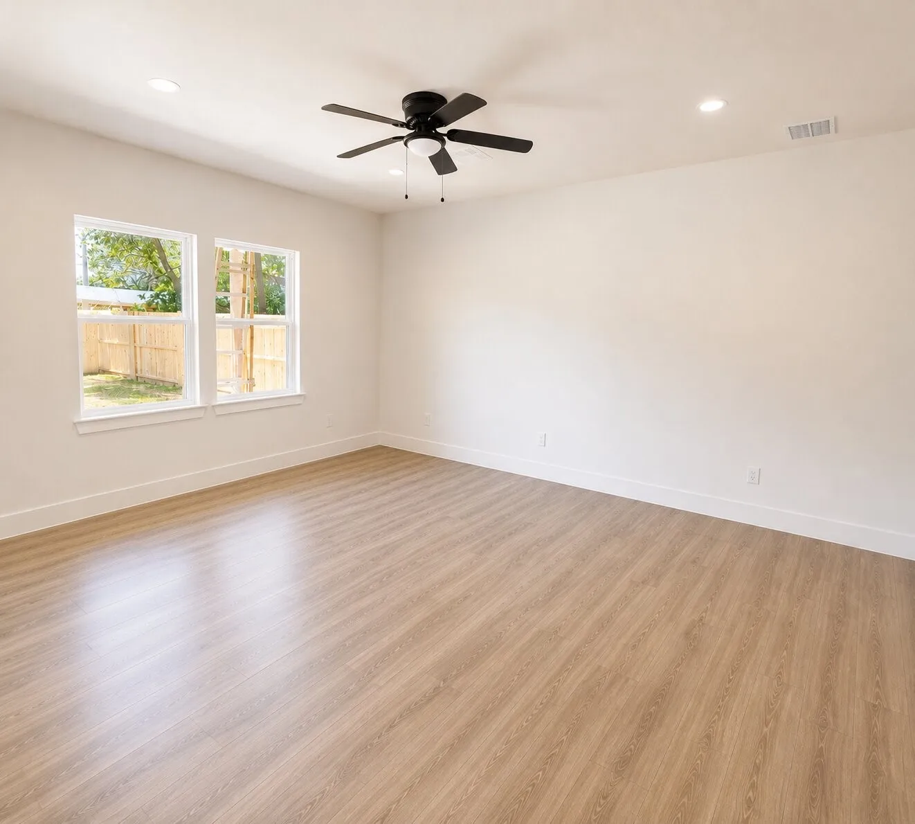 Spacious interior featuring wood-finish flooring, recessed lighting, and a contemporary ceiling fan