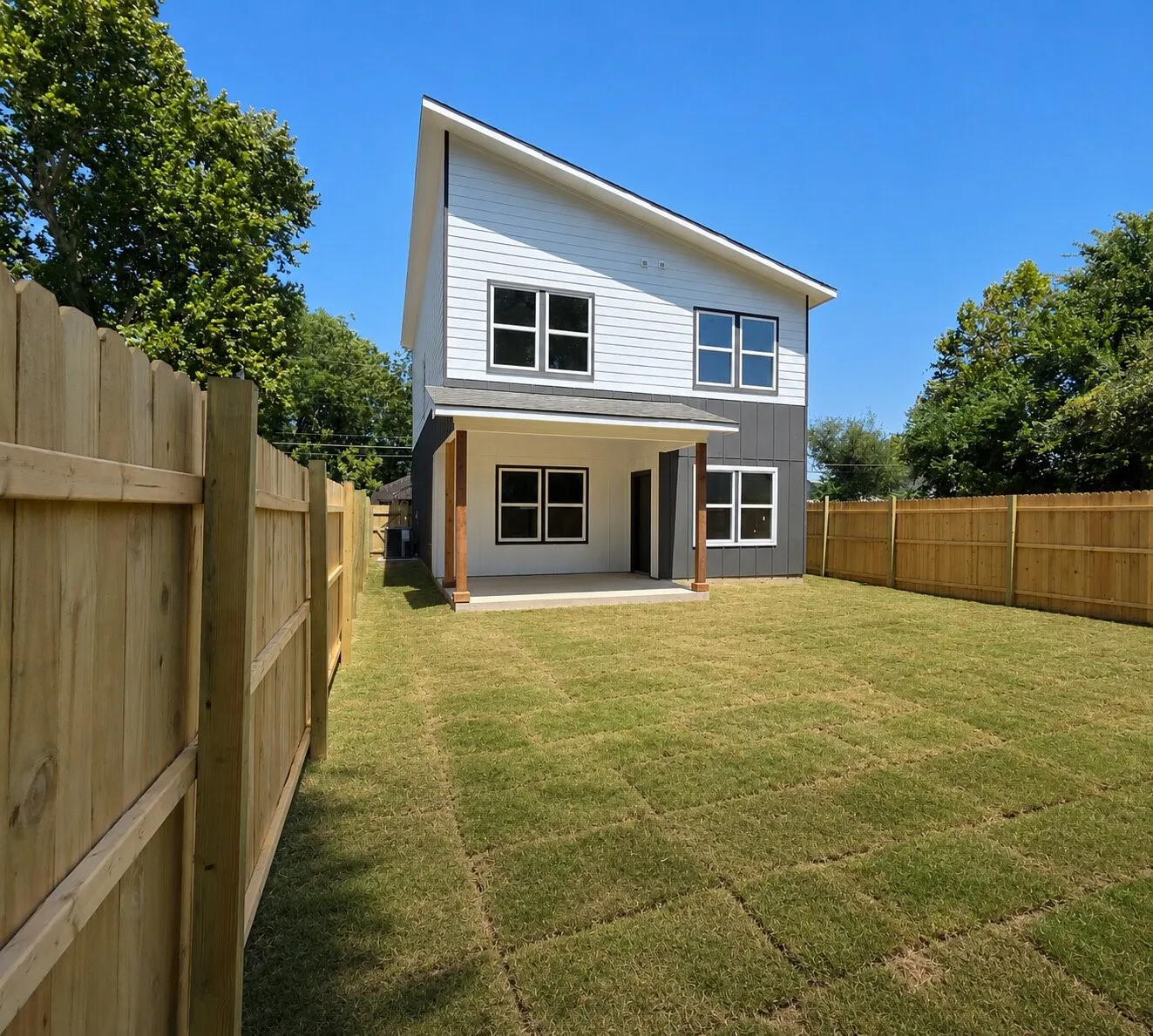 Contemporary exterior with a sharply angled roofline, white siding, and dark accent panels