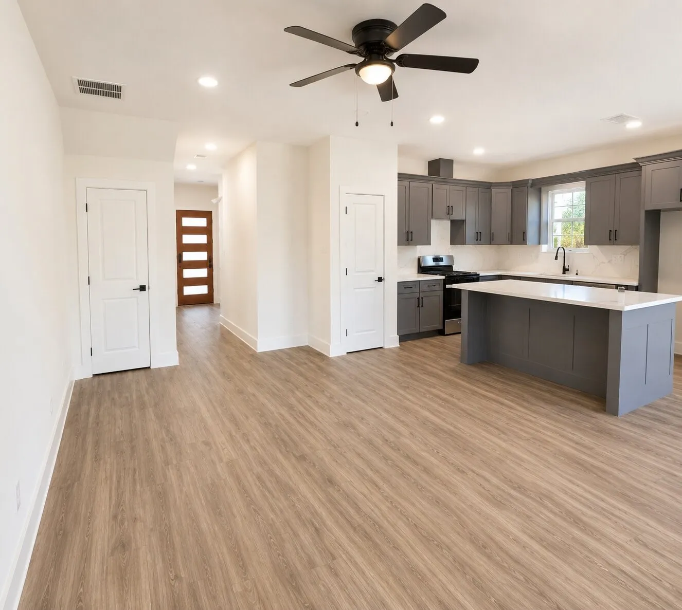 Open-concept living area with wood-finish flooring, a modern ceiling fan, and recessed lighting