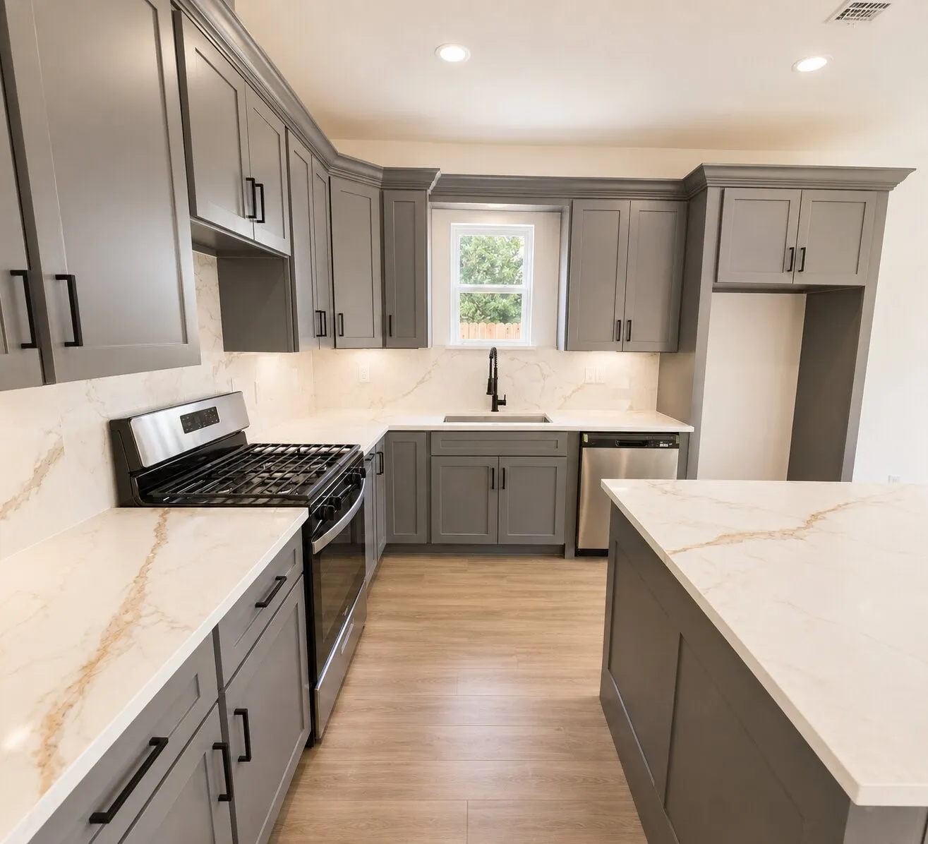 Grey shaker-style cabinetry, wood-finish flooring, stainless steel appliances, white countertops with veining, and a black faucet