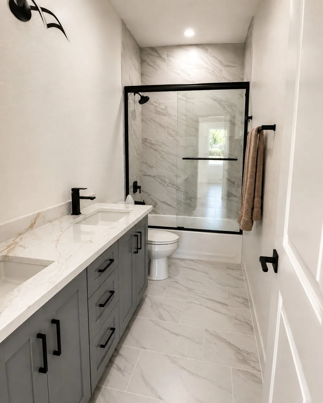 Dual sink vanity with stone-finish countertop, matte black fixtures, and gray cabinetry