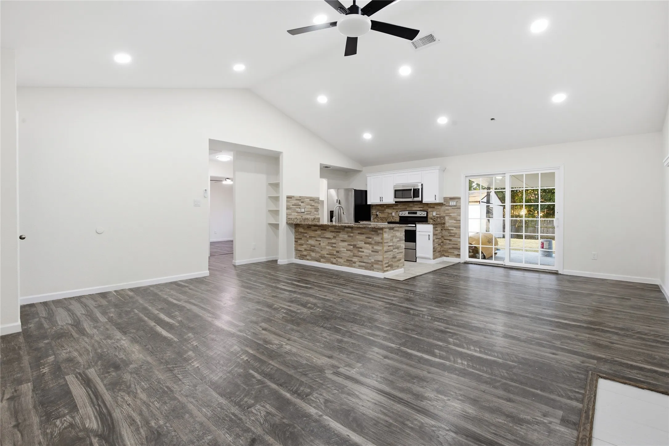 Vaulted ceiling with recessed lighting and a ceiling fan
