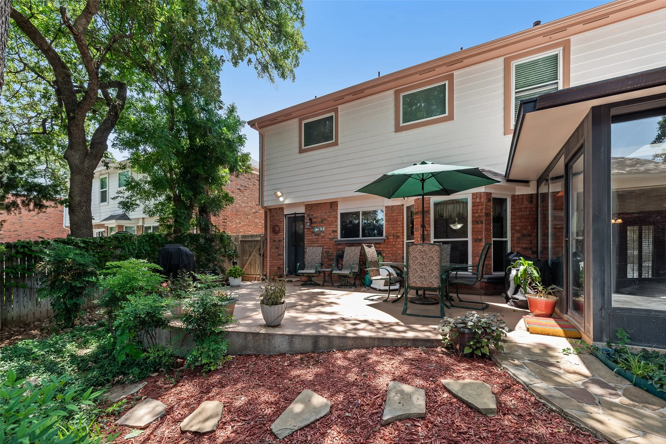 Private backyard featuring a paved patio and mature trees