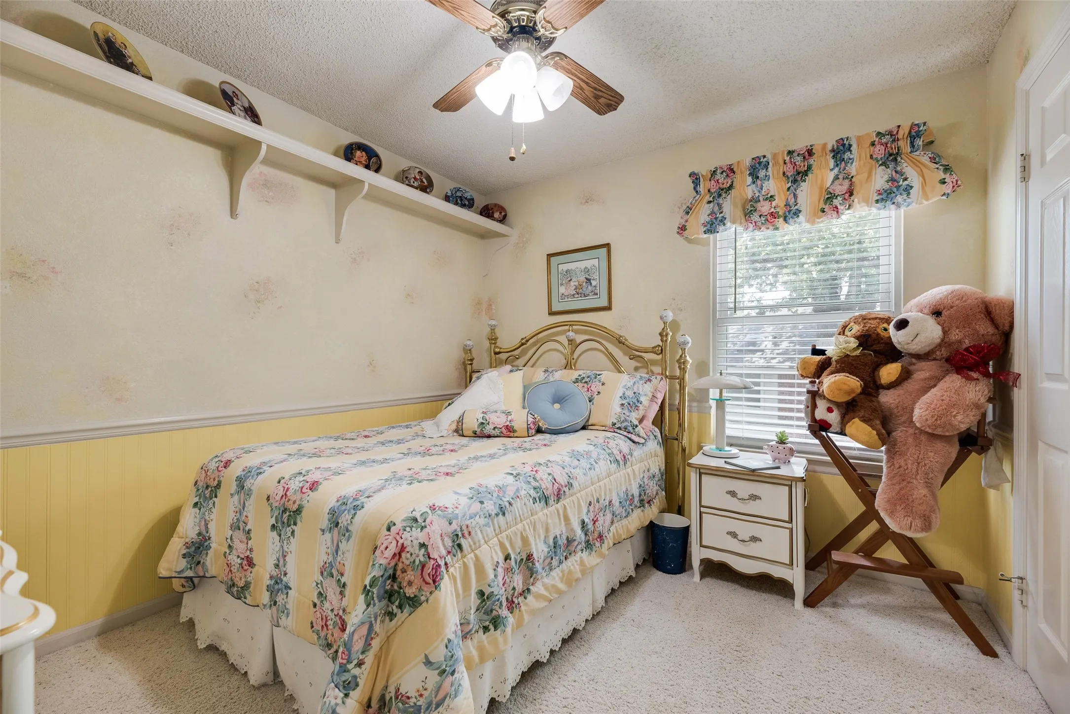 Popcorn ceiling with a ceiling fan, window with blinds, and white door