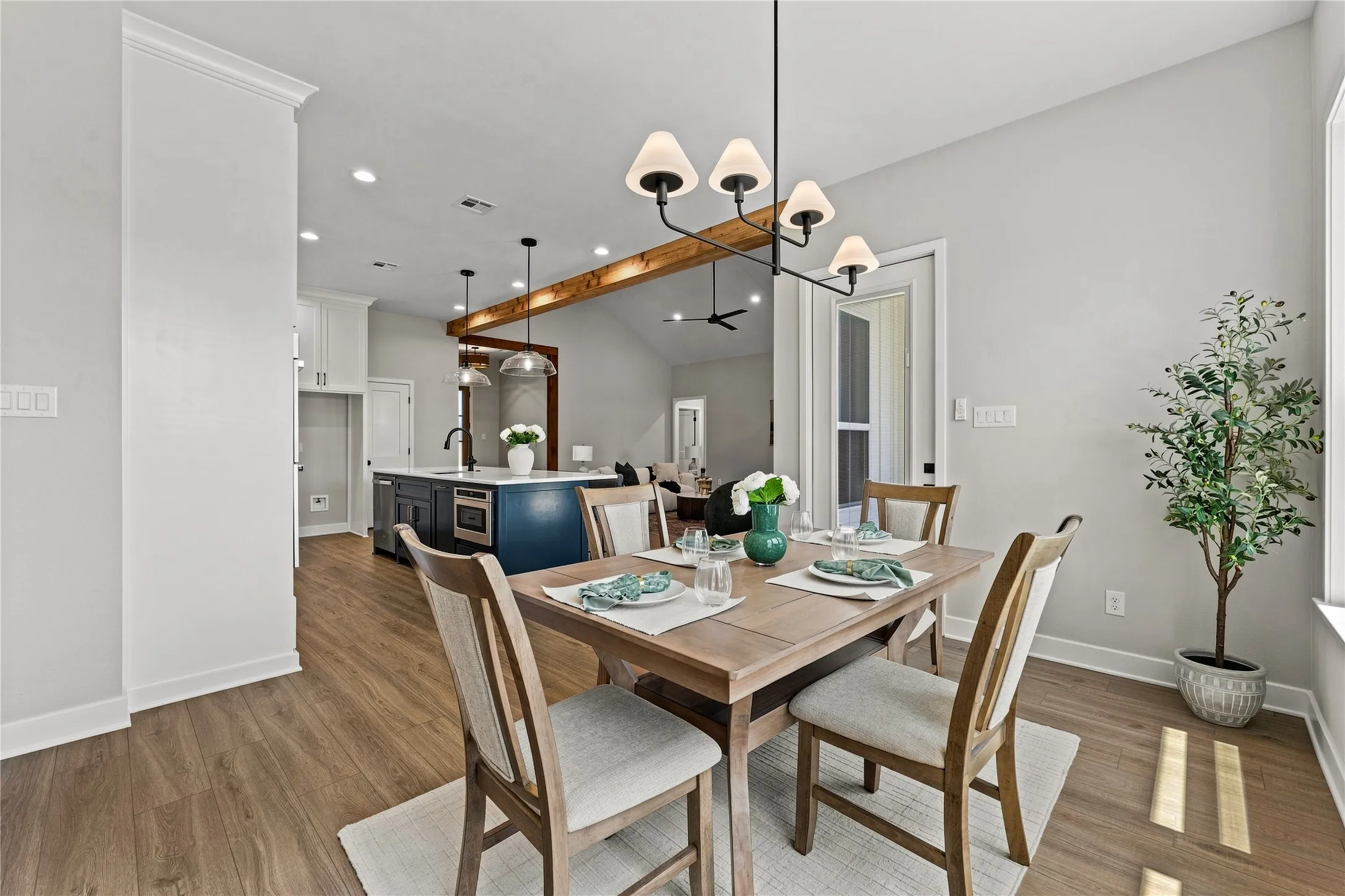 Open-concept living space featuring wood-finish flooring, recessed lighting, and a modern chandelier