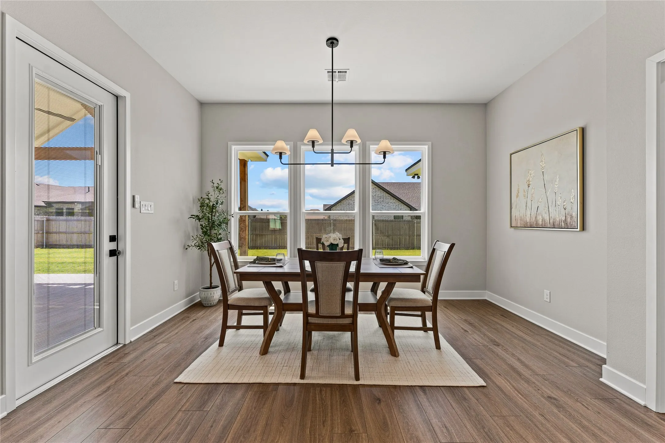 Wood-finish flooring throughout, complemented by a contemporary chandelier