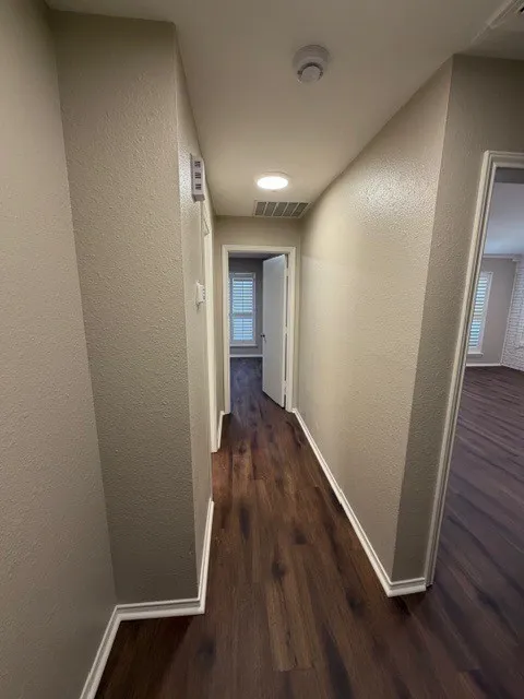 Wood-finish flooring throughout, recessed ceiling lighting, and white baseboards