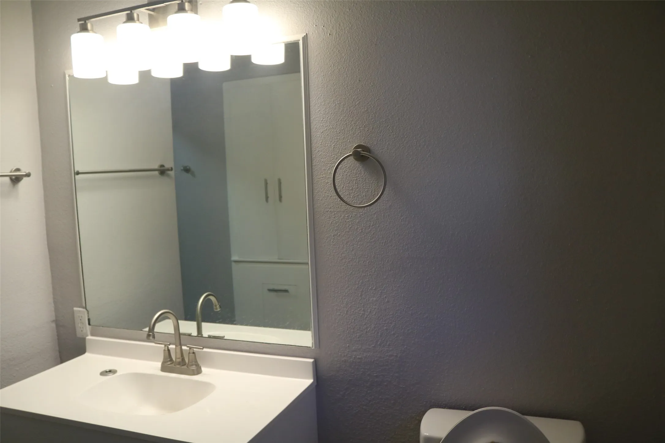 Modern bathroom featuring a clean-lined white vanity with an integrated sink, contemporary dual-handle faucet, and ample counter space