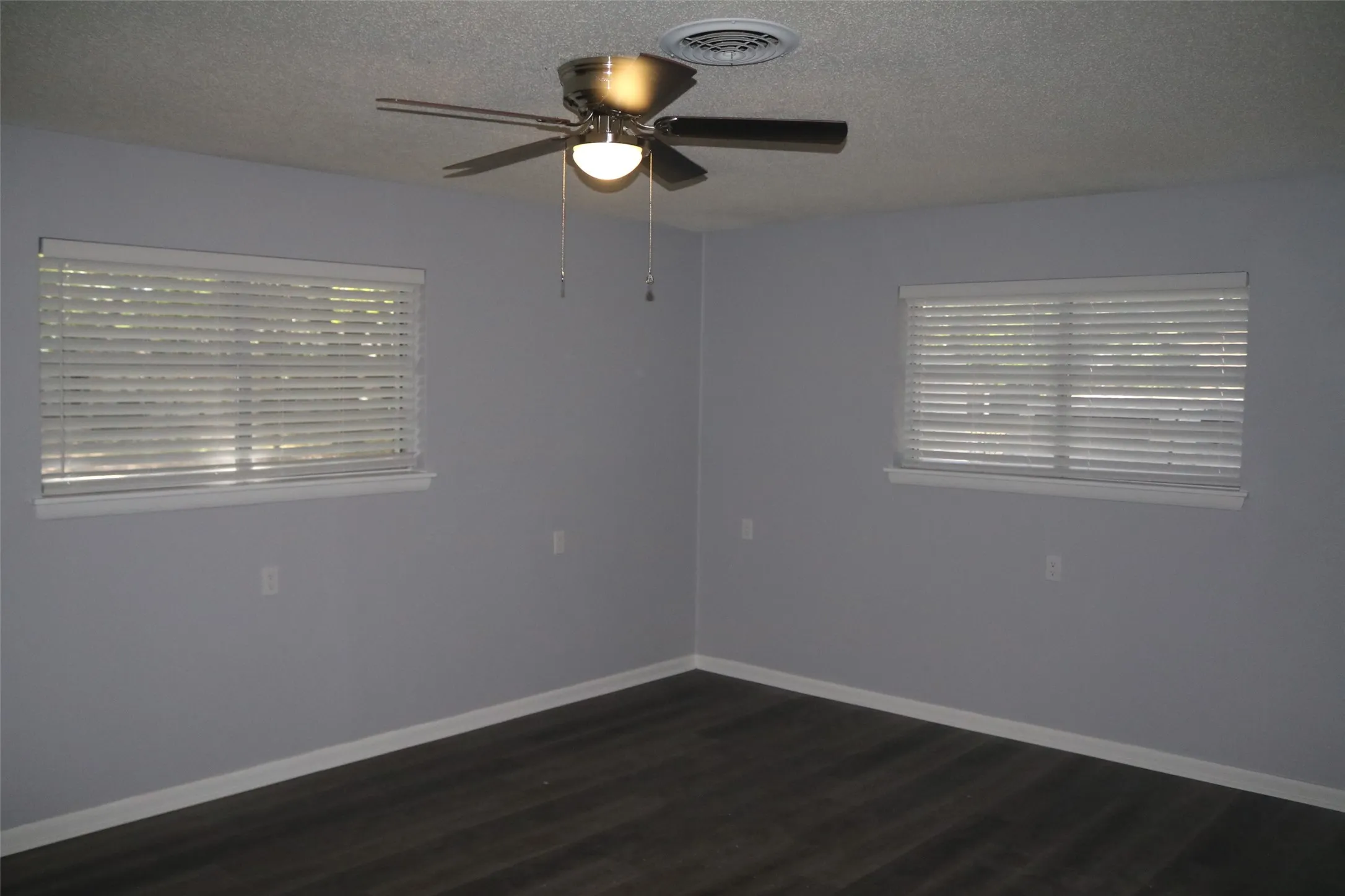Dark wood-finish flooring with light gray wall paint