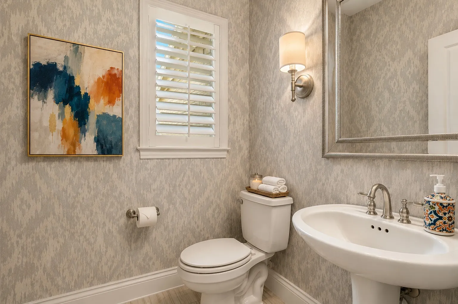 WE HAVE CREATED A BEAUTIFUL GUEST BATH WITH 3 SIMPLE TOUCHES, WALLPAPER, DECORATIVE SCONCE AND SHUTTERED WINDOW.