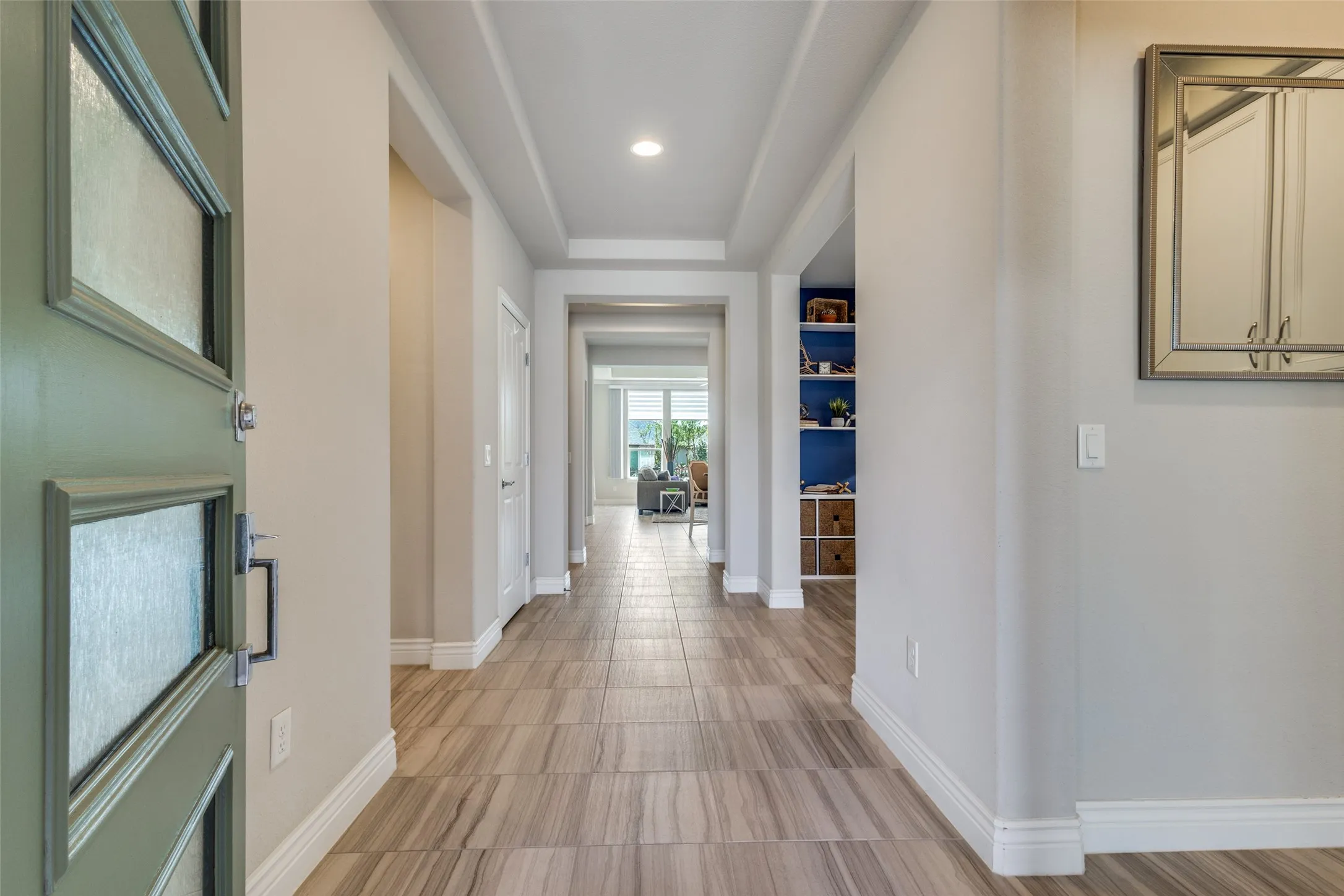 DIVIDED LIGHT FRONT DOOR, HIGH CEILINGS, CERAMIC TILE FLOORING IN SOFT TAUPE AND GREIGE.