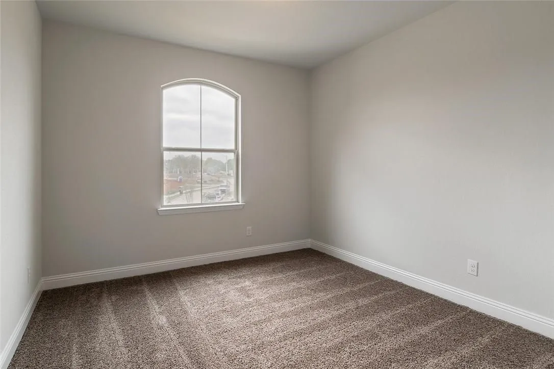 Arched window, light neutral wall color, brown carpet, white trim