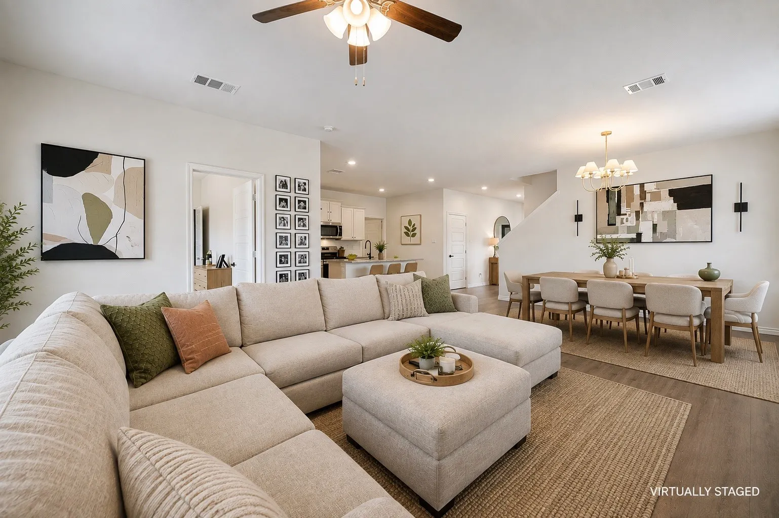 Open-concept living area featuring wood-finish flooring, a contemporary ceiling fan, recessed lighting, and a dining area with a modern chandelier