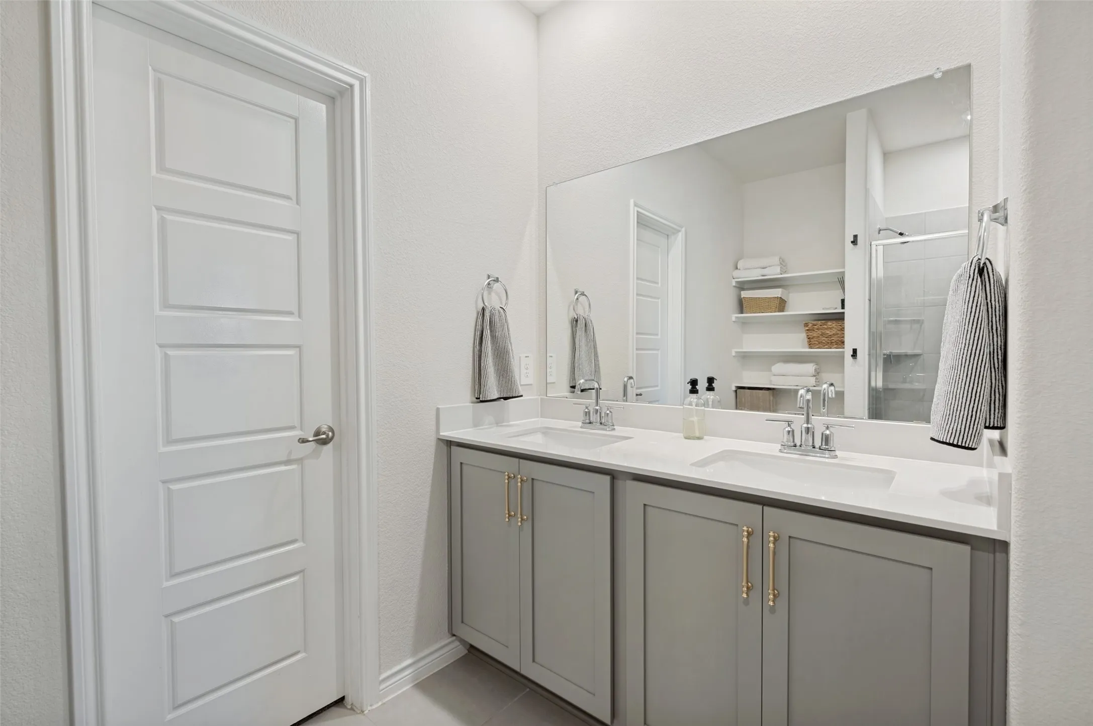 Double vanity with gray cabinetry, brushed nickel hardware, and white countertops
