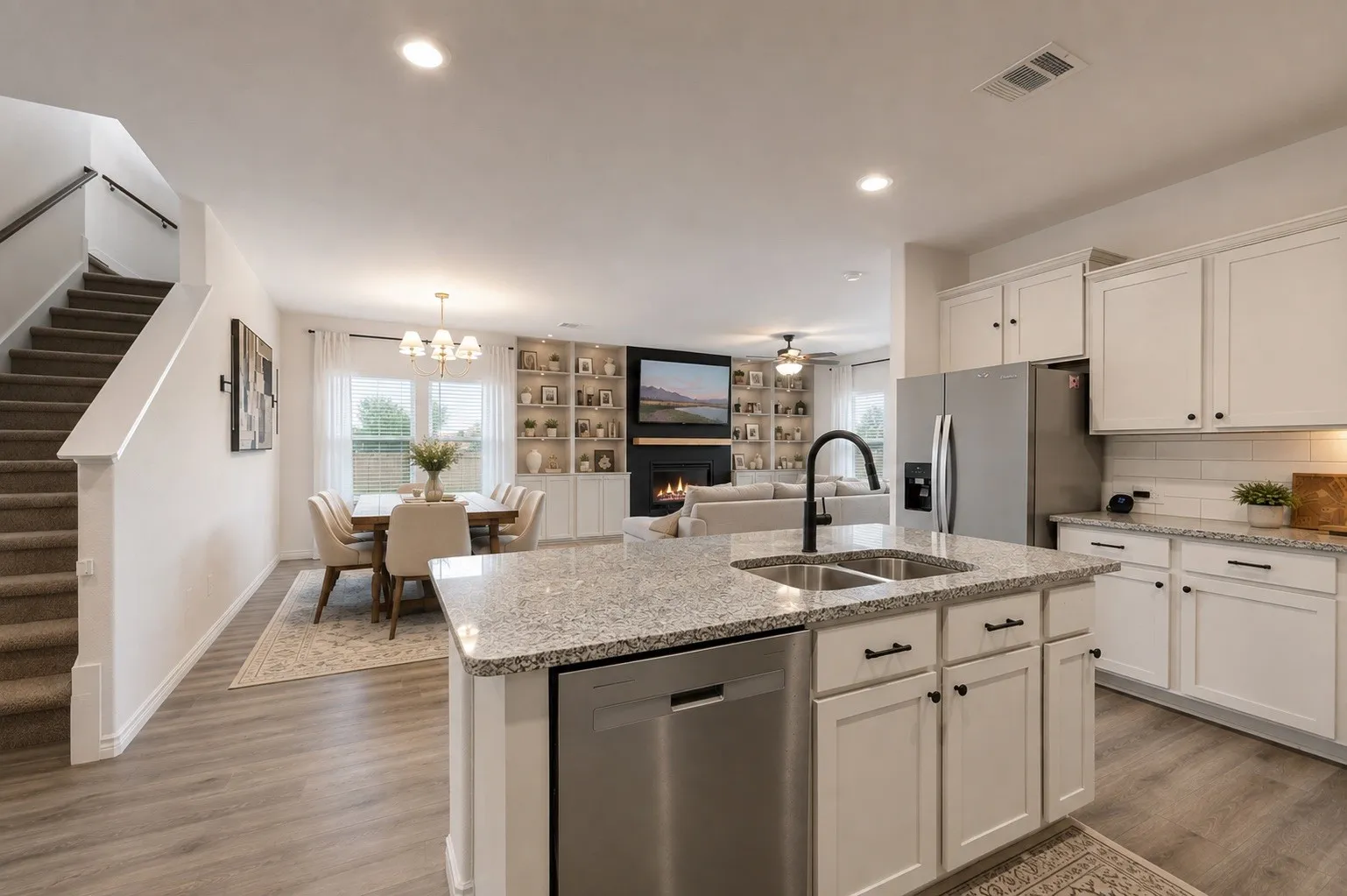 Kitchen featuring white cabinetry, stainless steel appliances, granite countertops, and a dual-basin sink with a matte black faucet
