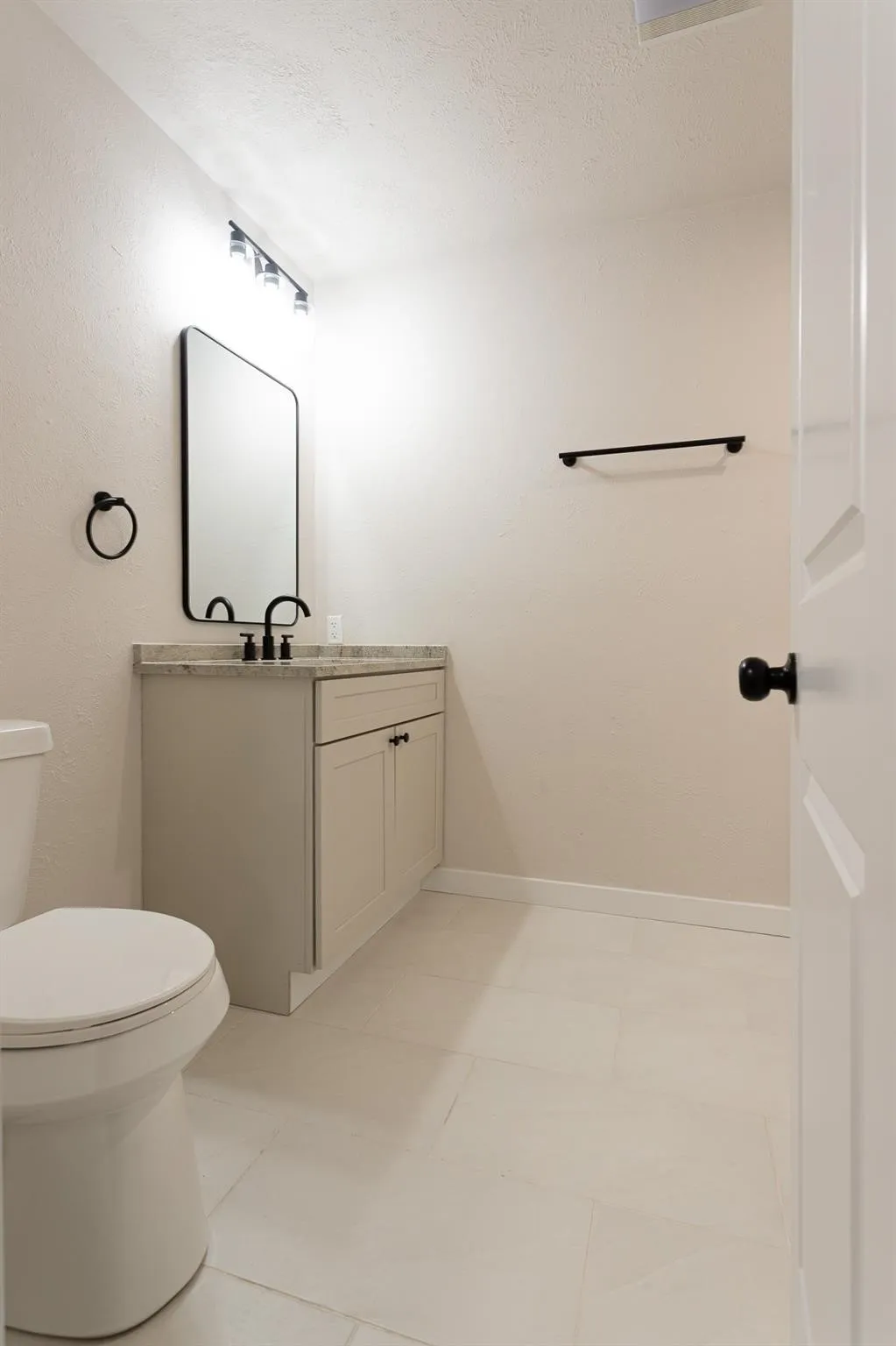 Secondary Bathroom -Vanity with a solid surface countertop, undermount sink, and matte black fixtures