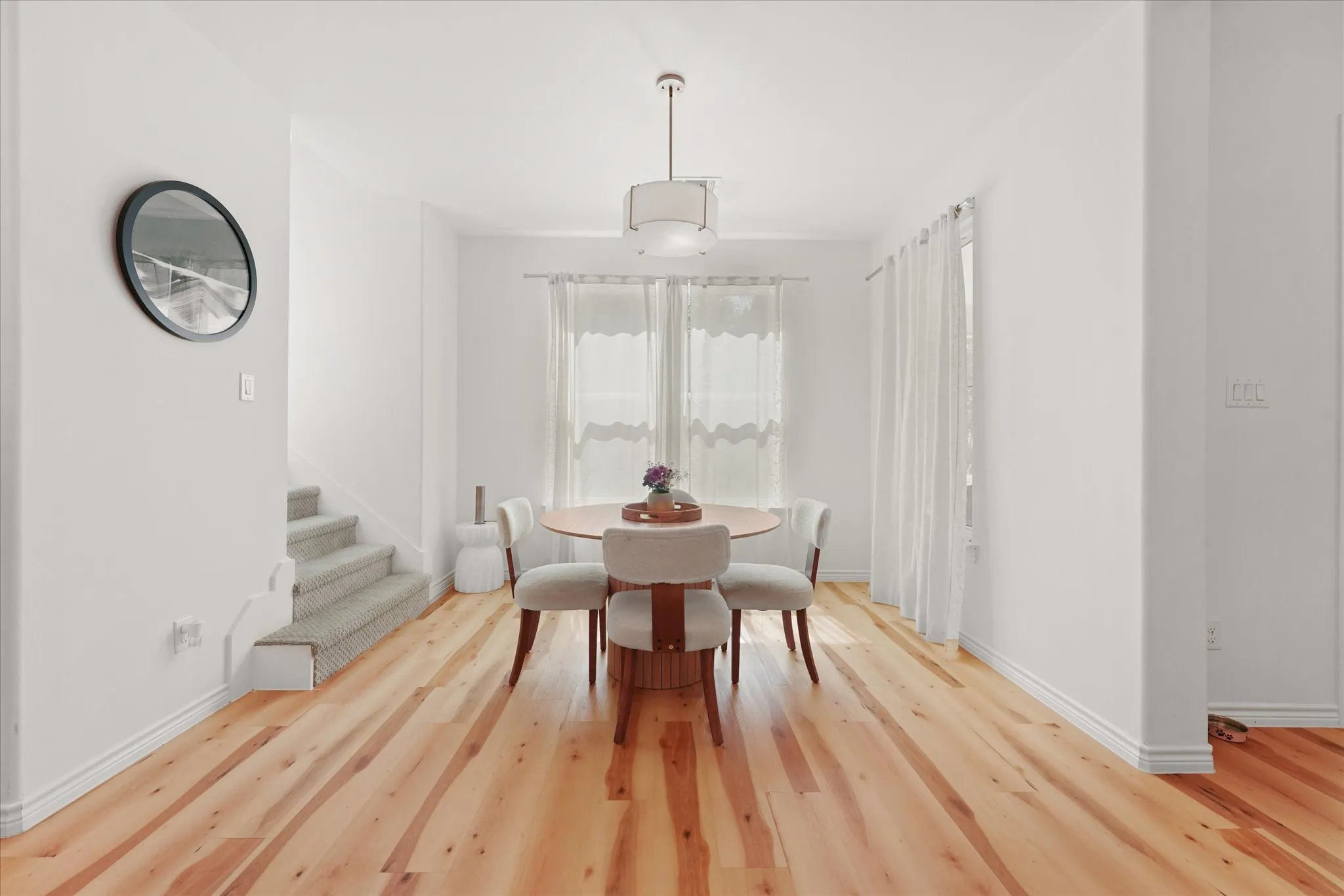 Hardwood flooring, recessed lighting, white walls, large window, and staircase with carpeted treads